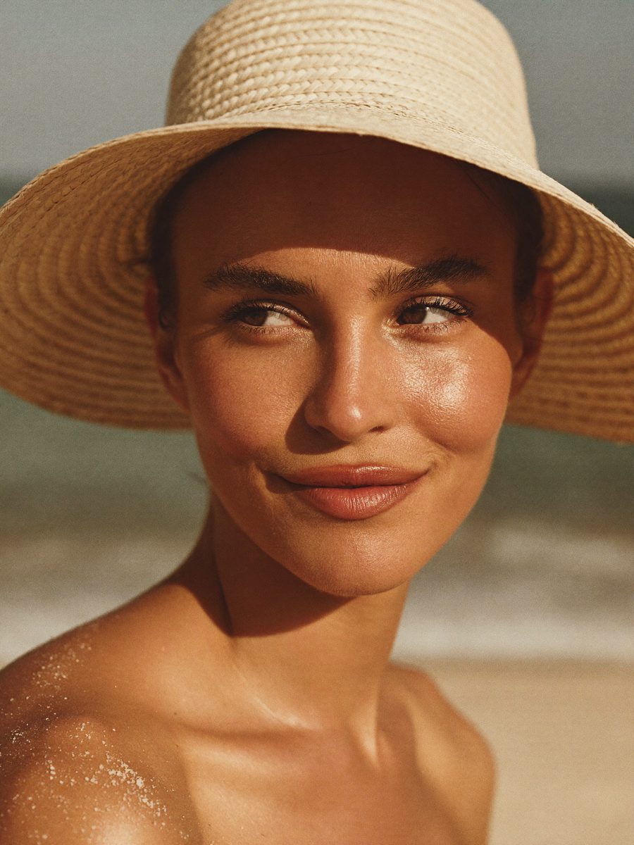 Woman in a wide-brim straw hat at the beach